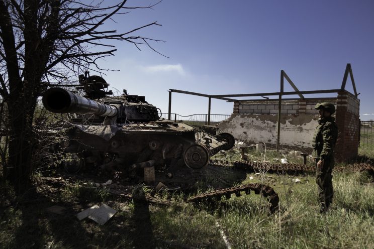 Kominternove - Repubblica popolare di Donetsk - Un soldato DPR osserva un carroarmato Ucraino distrutto.
