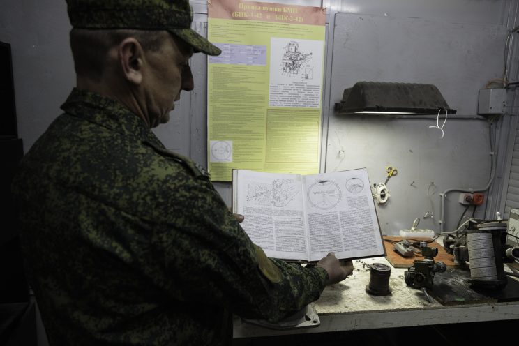 Base Riparazioni - Donetsk - Repubblica Popolare di Donetsk -2018. Il sergente Nikolai ci mostra il suo piccolo ufficio dove aggiusta i componenti ottici dell'attrezzatura.